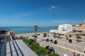 Vista costera con un estacionamiento, edificios y cielo despejado.