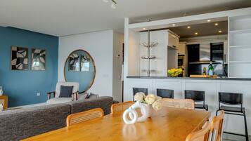 A modern kitchen with white cabinets, a black countertop, and a fruit bowl.