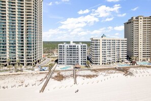 Ein Strandhotel mit mehreren Hochhäusern, einem Sandstrand und einem Poolbereich.