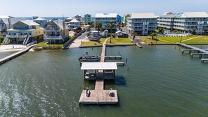 A waterfront property with a dock, a pool, and a building with balconies. - 2BR Condo w/ pool, lagoon view & deeded beach access - Sleeps 6 (Gulf Shores)