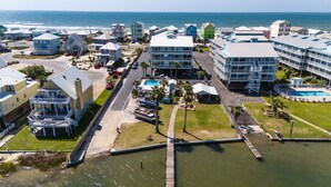A coastal hotel with multiple buildings, a swimming pool, and a dock. - 2BR Condo w/ pool, lagoon view & deeded beach access - Sleeps 6 (Gulf Shores)