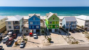 A coastal residential area with colorful houses, a beach, and a clear view of the ocean. - 2BR Condo w/ pool, lagoon view & deeded beach access - Sleeps 6 (Gulf Shores)