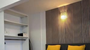 Et moderne soveværelse med seng, indbyggede hylder og en vægmonteret lampe.