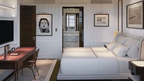 A bedroom with a bed, desk, chair, and a television. - Cipriani Punta Del Este  (Punta del Este)