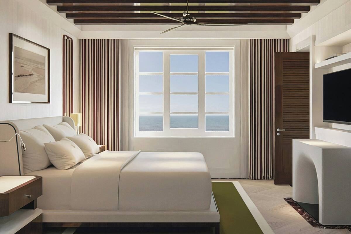 A modern hotel room with a bed, a TV, a window with a view, and a ceiling fan.