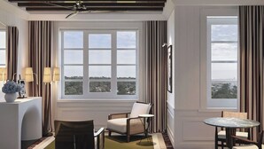 A modern room with a large window, a sofa, a chair, a small table, and a lamp. - Cipriani Punta Del Este  (Punta del Este)