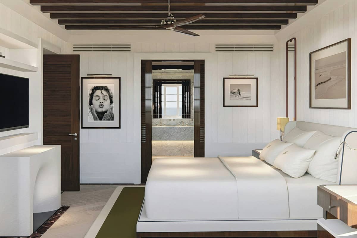 A modern bedroom with a large bed, a television, and artwork on the walls.