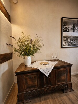 A wooden cabinet with a white vase of flowers and a decorative tray with glasses. - Landhaus am See - Apartments Reiherbachtal and Klingetal, directly on Lake Edersee (Waldeck - Nieder-Werbe)
