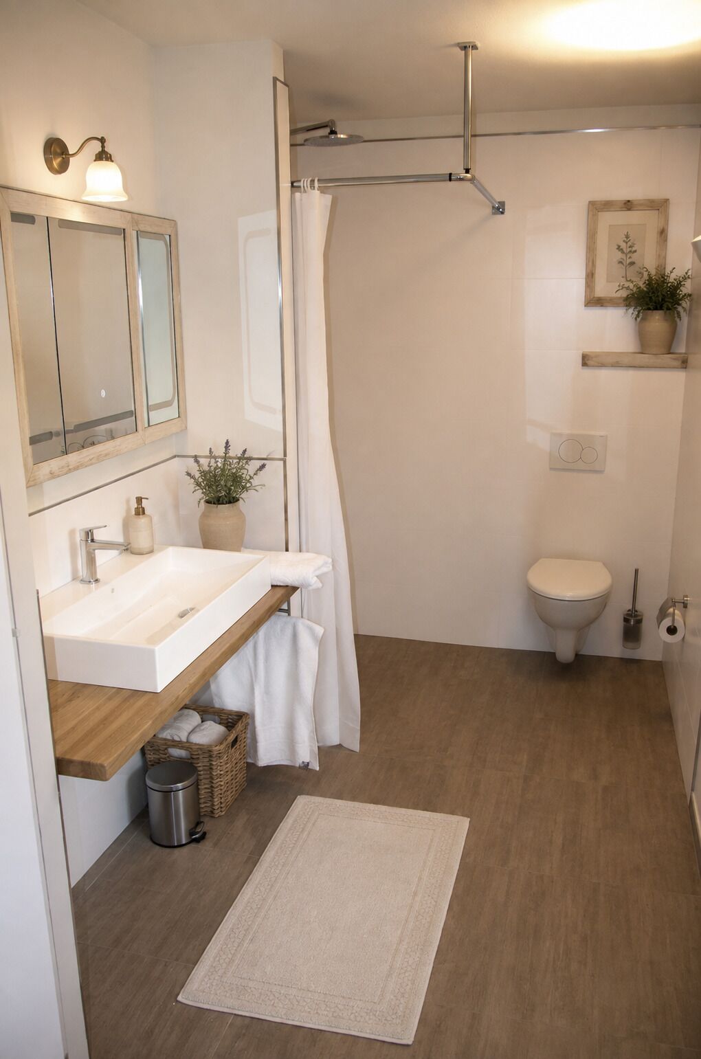 A bathroom with a wooden vanity, a white sink, a shower with a glass door, a toilet, and a small potted plant on a shelf.