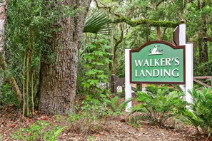 A sign labeled 'Walker’s Landing' in a forested area with trees and ferns. - Oceanfront Turtle Dunes 5th Floor RENOVATED - Private Balcony - Beach & Pool! (Fernandina Beach)