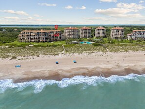 A beachfront hotel with multiple buildings, a sandy beach, and a clear view of the ocean. - Oceanfront Turtle Dunes 5th Floor RENOVATED - Private Balcony - Beach & Pool! (Fernandina Beach)