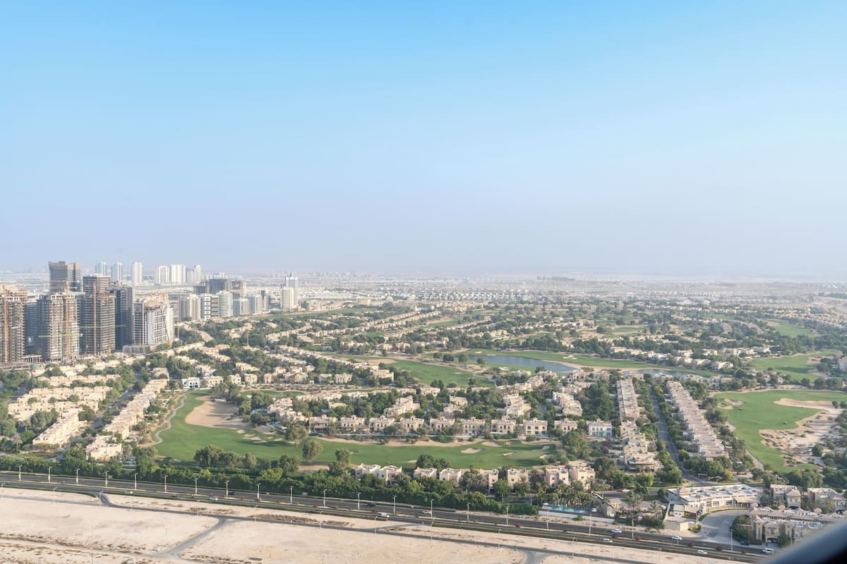 Paisagem urbana com edifícios altos, áreas residenciais e uma autoestrada.