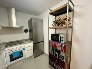A compact kitchen with a stainless steel refrigerator, a microwave, and a built-in oven. - Estepona Center, Pool and Beach (Estepona)