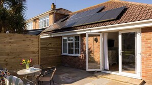 A house with a brick exterior, a tiled roof, and a solar panel installation. - Stylish One Bed Annexe Near Marina and Beaches (Chichester)