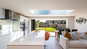 Une cuisine moderne dotée d’un grand îlot central, d’un aménagement ouvert et donnant sur le jardin.