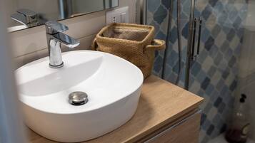A bathroom with a white sink, chrome faucet, and a wooden vanity.