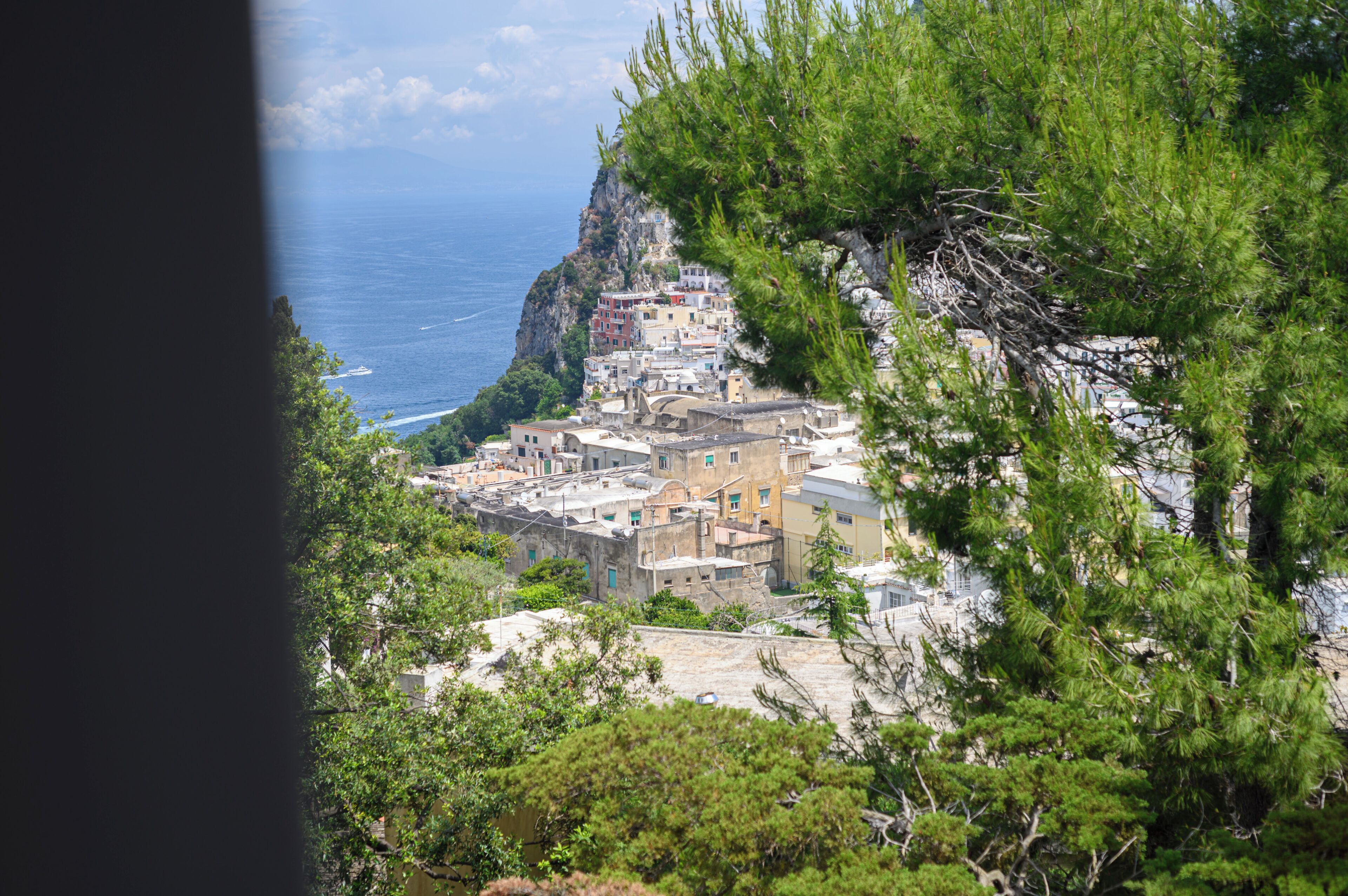A coastal village with buildings perched on a cliff, overlooking the sea.