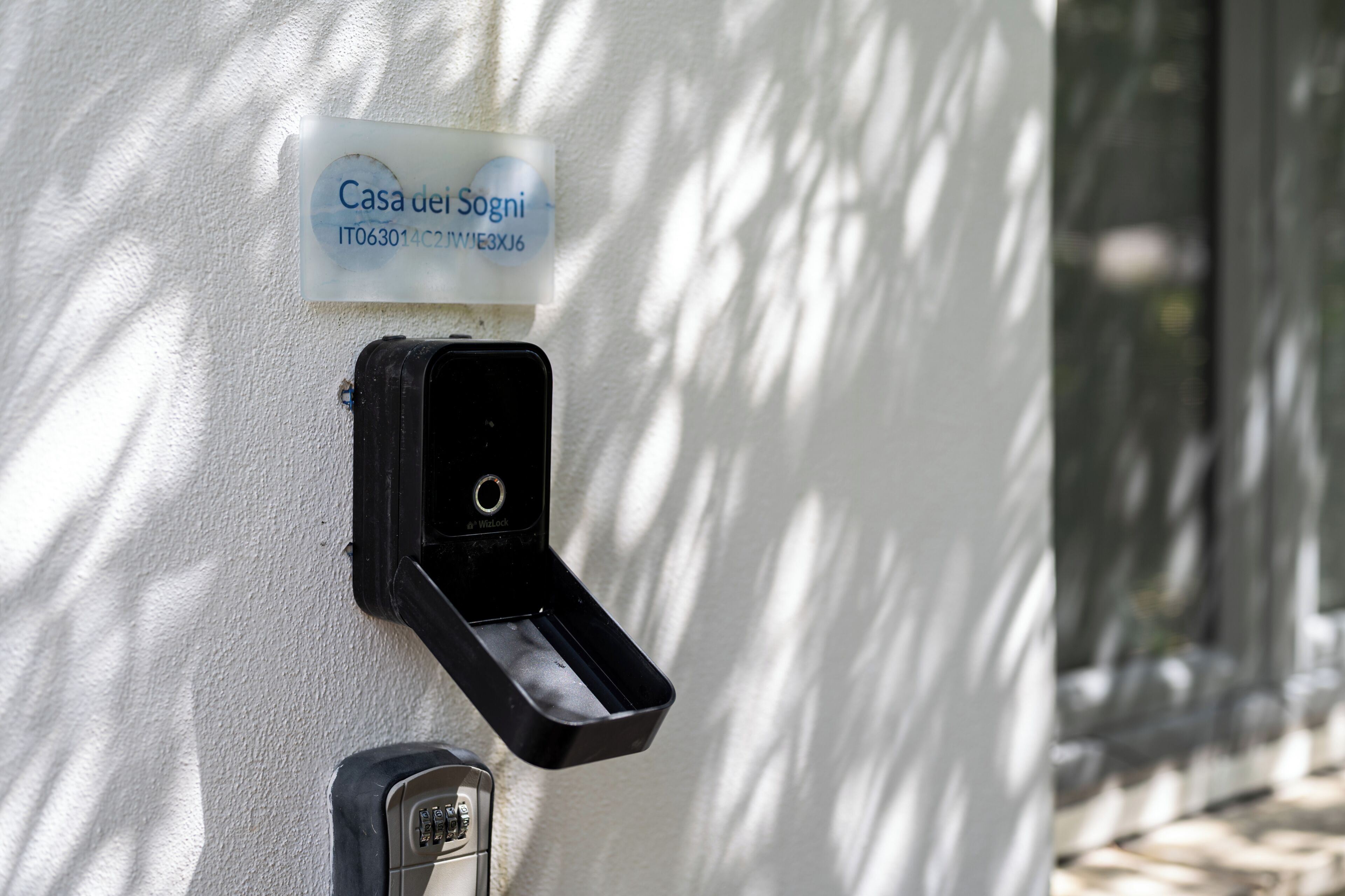 A wall-mounted device, a sign with 'Casa dei Sogni' text, and a door lock.