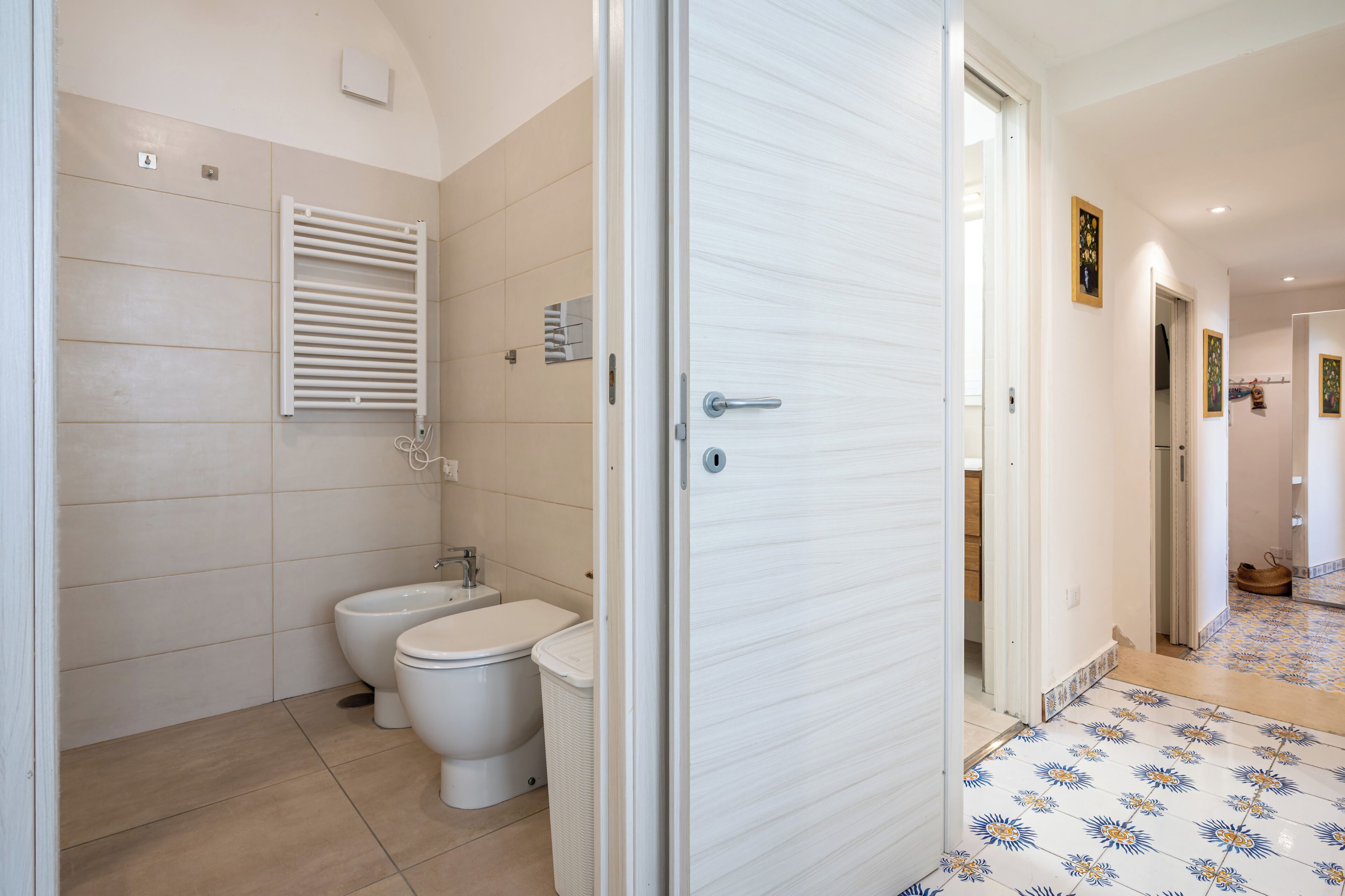 Un bagno con il water, bidet e porta asciugamani.