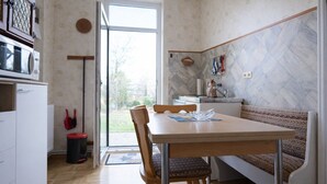 A kitchen with a dining table, chairs, a bench, a microwave, and a window. - Your perfect time-out in Duhnen - cozy, central and close to the beach (Cuxhaven)