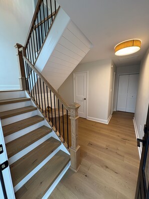 A staircase with wooden steps and black railings leading to a landing. - Beautifully Renovated 4br Home on Avalon - Stone Harbor Border - Pet Friendly (Avalon)