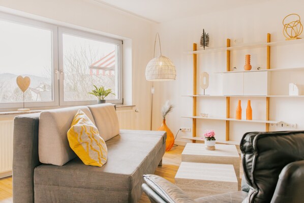Un salon moderne avec un canapé, une table basse et une bibliothèque.