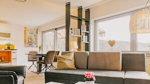 A modern living room with a sofa, coffee table, and bookshelf.