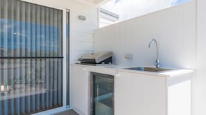 A modern kitchen with a built-in oven, a sink, and a glass door refrigerator. - Marina 14, Harrington (Harrington)