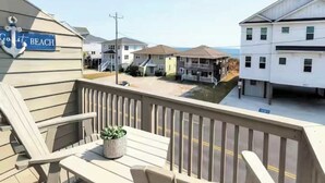 A beachside property with a balcony, a sign reading 'Crest Beach,' and a view of the ocean and neighboring buildings. - "Dune Delight" At Sea Mystic (North Myrtle Beach)