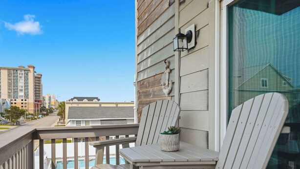 A balcony with two Adirondack chairs, a small table, and a potted plant. - "Dune Delight" At Sea Mystic (North Myrtle Beach)
