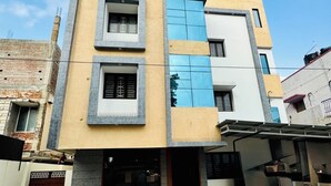 Un edificio de varios pisos con techo plano, garaje y un espacio exterior cubierto.