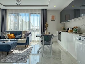 Una sala de estar moderna con un sofá, una mesa de comedor y una cocina con un lavamanos y armarios.