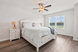 A bedroom with a bed, nightstands, a ceiling fan, and a window with blinds. - "Surfside Beach Oasis" (Myrtle Beach)