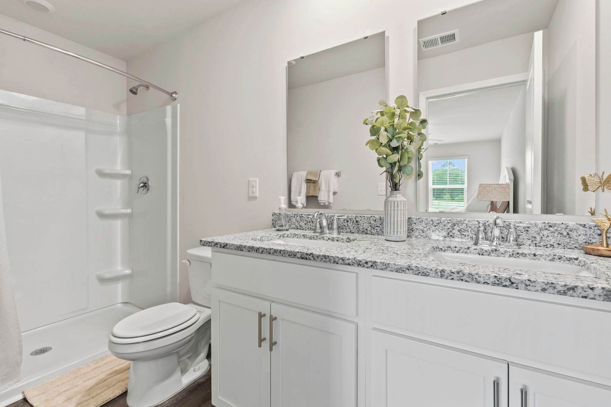 A bathroom with a shower, toilet, and sink.