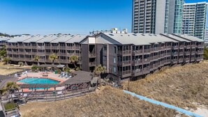 A modern hotel with multiple balconies, a pool, and a beachside location. - Orange Crush at Tilghman (North Myrtle Beach)