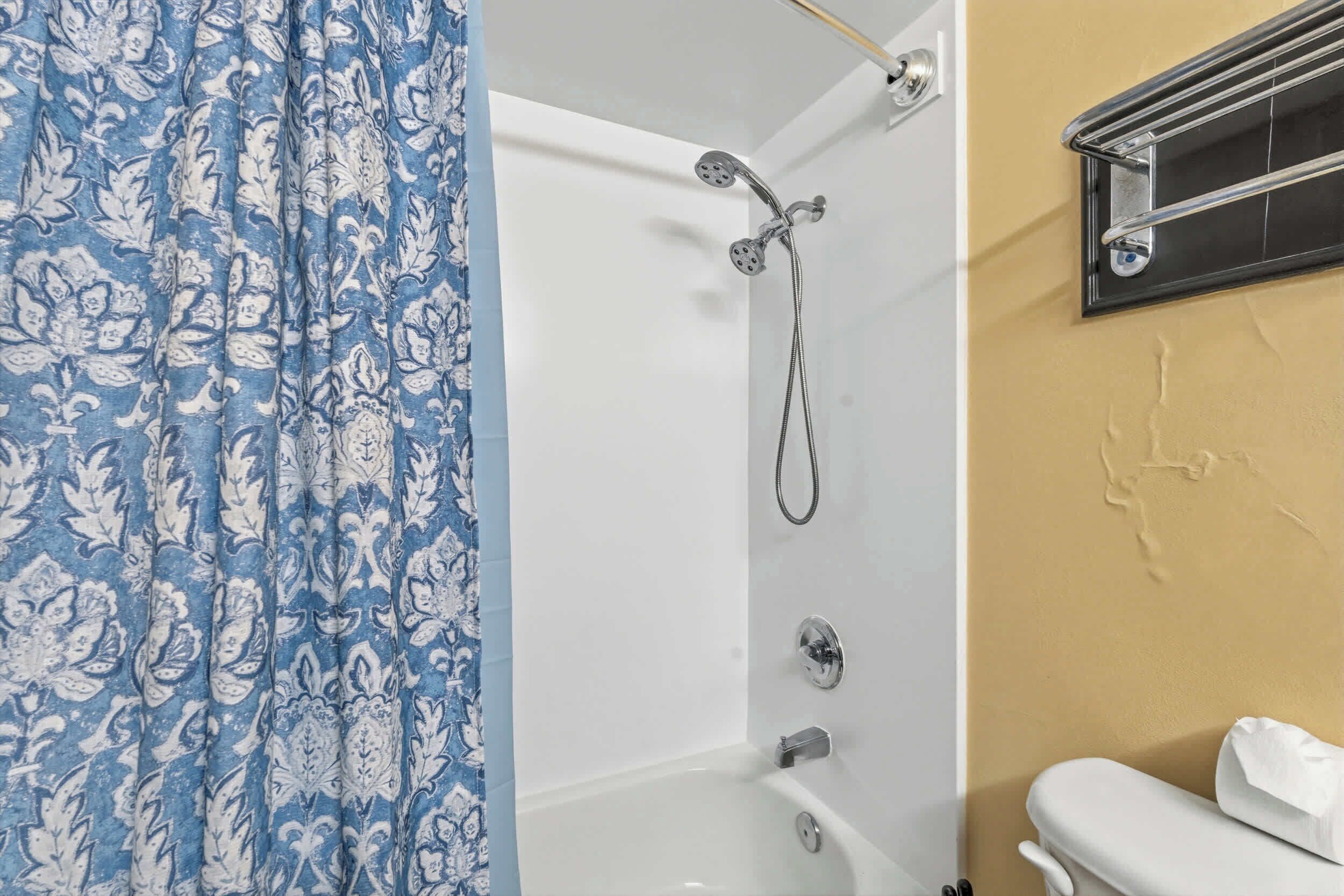 A bathroom with a shower, a bathtub, and a toilet.