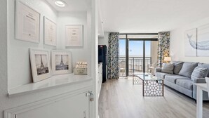 Ein modernes Wohnzimmer mit einer Couch, einem Couchtisch und Kunstwerken an den Wänden.