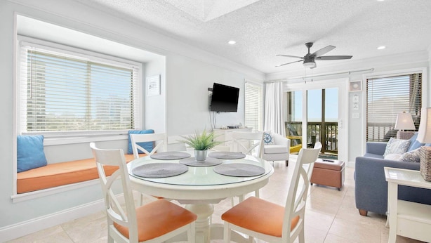 A dining area with a round table, white chairs, and a ceiling fan. - "The Pearl of Tilghman" (North Myrtle Beach)