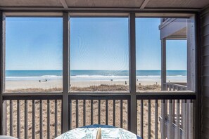 A room with a large window overlooking a beach. - Tequila at Tilghman Resort (North Myrtle Beach)