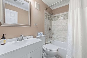 Een badkamer met een wit wastafel, toilet en bad.