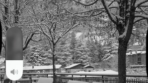 Ein mit Schnee bedeckter Park mit Bänken und einem Zaun.