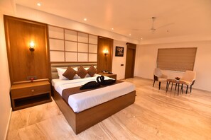 Un dormitorio moderno con una cama grande, mesitas de noche, un escritorio y una silla.