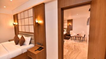 A hotel room with a bed, bedside table, and a desk with chairs.