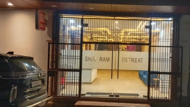 A gated entrance to a building labeled 'SHRI RAM RETREAT' with a visible car parked outside. - Shri Ram Retreat (Vrindavan)