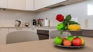 Una cucina con un vaso di frutta e fiori su un tavolo.