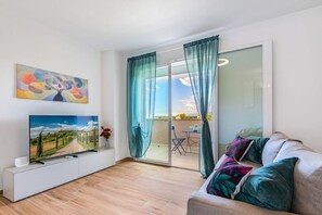 A modern living room with a flat-screen TV, a painting, and a sofa with cushions. - Terrace- new - 900m Tower -Park priv- spacious (Pisa)