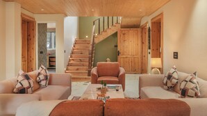 Ein modernes Wohnzimmer mit einer Holztreppe, zwei Sofas und einem Couchtisch.