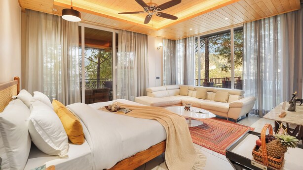 Ein Schlafzimmer mit Bett, einer Couch, einem Couchtisch und einem Deckenventilator.