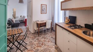 Een compacte woonruimte met een eethoek, een kitchenette en een klein zithoekje.