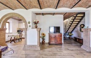 A spacious living area with a fireplace, a television, and a staircase leading to another level. - 3 bedroom gorgeous home in Montecatini Val Di Cec (Montecatini Val Di Cec)